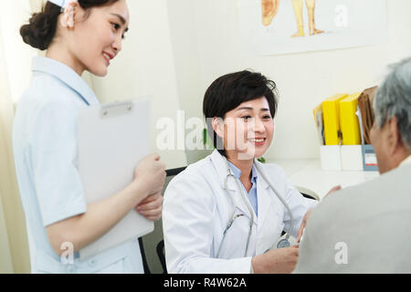 Les travailleurs médicaux et les patients dans le cabinet du médecin Banque D'Images