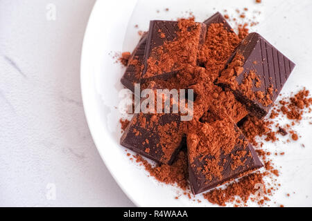 Brisures de chocolat foncé avec du cacao en poudre sur une assiette. Close up. Banque D'Images