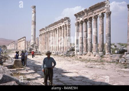 Vue panoramique sur les anciennes colonnes debout le long des ruines du Cardo Maximus à Apamée, en Syrie, en juin 1994. Les touristes occidentaux sillonnent la visualisation du site archéologique des vestiges de la vieille ville. () Banque D'Images