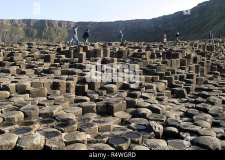 Les visiteurs et les touristes se promener sur la Chaussée des Géants, en Irlande du Nord, qui est 40 000 colonnes de basalte, enclenchement, qui a émergé après une énorme éruption volcanique, il y a de nombreuses années. C'est un site du patrimoine mondial de l'UNESCO et est visité par des milliers de personnes chaque année. Banque D'Images