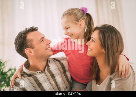 Belle jeune smiling family relaxing on sofa au salon. Banque D'Images