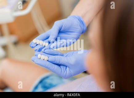 Dentiste montrant des couronnes en porcelaine au patient. Close-up. Focus sélectif. Se concentrer sur les couronnes. Banque D'Images