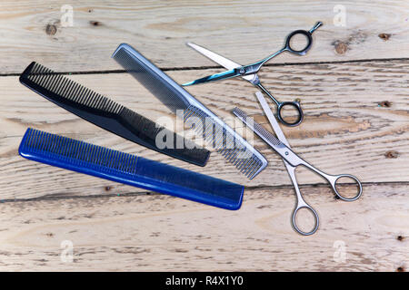 Salon de coiffure ciseaux, peigne et brosse, le pulvérisateur pour les cheveux s'allonger sur une planche en bois Banque D'Images