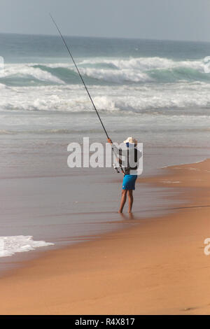 Une vue rapprochée de la face d'un pêcheur La pêche sur la rive sur une belle journée d'été ensoleillée sur une plage de Durban Banque D'Images