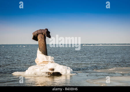 Grande ancre métal gelé dans l'eau de mer glacée. Banque D'Images