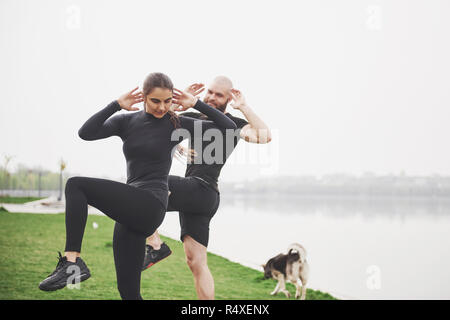 Un jeune couple aime jouer au sport dans la matinée à l'air libre. Réchauffer avant l'exercice Banque D'Images