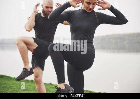 Un jeune couple aime jouer au sport dans la matinée à l'air libre. Réchauffer avant l'exercice Banque D'Images