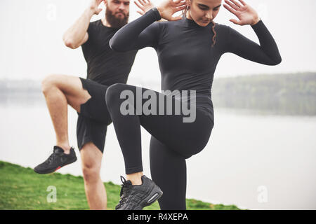 Un jeune couple aime jouer au sport dans la matinée à l'air libre. Réchauffer avant l'exercice Banque D'Images