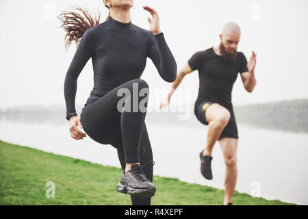 Un jeune couple aime jouer au sport dans la matinée à l'air libre. Réchauffer avant l'exercice Banque D'Images