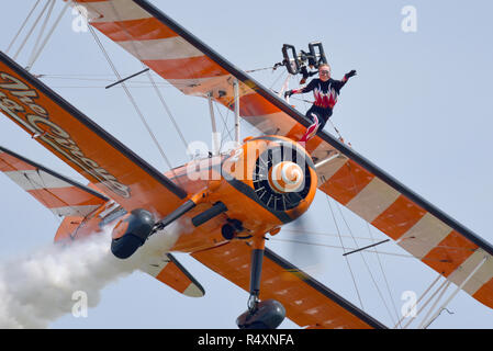 The Flying Circus, anciennement Breitling, Wingwalkers équipe d'exposition de wingwalking volant à un spectacle aérien.Boeing Staarman avion biplan avec une fille à l'aile Banque D'Images