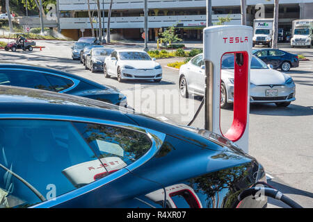 La batterie Tesla powered voitures attendre dans une longue lignée d'un espace à la station de charge Super Tesla au Westfield Mall à Culver City, Californie. Banque D'Images