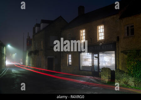 Boulangerie sur l'eau dans le brouillard avant l'aube en Bourton On The Water en automne. Kingham, Cotswolds, Gloucestershire, Angleterre Banque D'Images