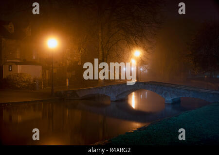 La brume et le brouillard avant l'aube dans le village de Cotswold Bourton On The Water en automne. Kingham, Cotswolds, Gloucestershire, Angleterre Banque D'Images