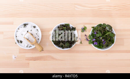 Bols en porcelaine avec du sel aux herbes fraîches et séchées, lierre terrestre Banque D'Images