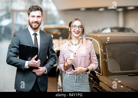 Portrait d'une belle femme avec un vendeur dans le showroom permanent client Banque D'Images