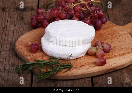 Le Camembert de raisins et de romarin sur un fond de bois Banque D'Images