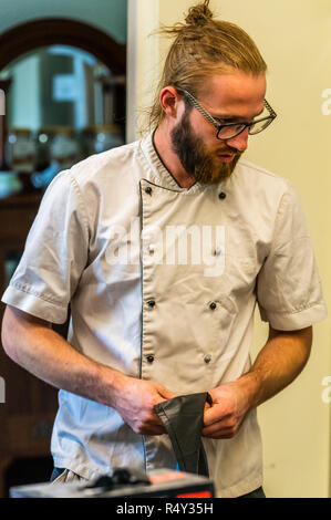 Young male Chef pense à un dîner de mariage Préparation - chemise blanche, arrière-plan flou Banque D'Images