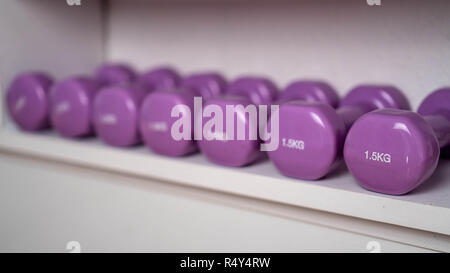 Poids multi-couleurs dans le centre de remise en forme féminine. kettlebells sont sur les étagères dans la salle de sport Banque D'Images