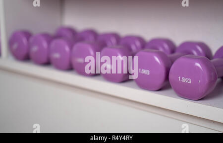 Poids multi-couleurs dans le centre de remise en forme féminine. kettlebells sont sur les étagères dans la salle de sport Banque D'Images