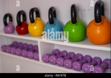 Poids multi-couleurs dans le centre de remise en forme féminine. kettlebells sont sur les étagères dans la salle de sport Banque D'Images