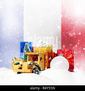 Noël arrière-plan.camion jouet avec des cadeaux, Nouvel An, sapin boules dans la neige et drapeau Français Banque D'Images