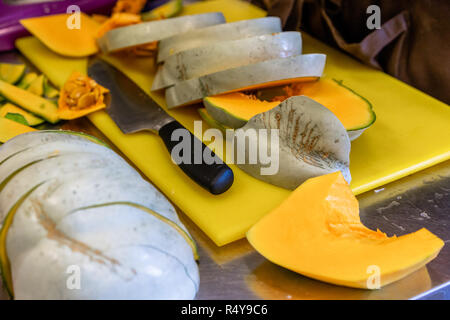 Les morceaux de potiron coupé sur le bord en plastique jaune - Set de cuisine Banque D'Images