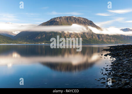 Lever du soleil illumine la montagne qui se reflète sur la surface de l'eau dans Skibotn, Norvège Banque D'Images