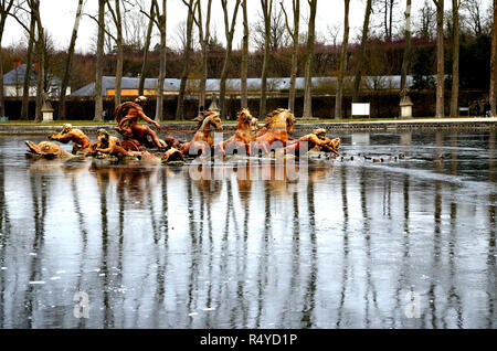 Fontaine d'Apollon, Château de Versailles. Sur une eau gelée, reflet de la fontaine d'Apollon avec des arbres sur une journée d'hiver. Banque D'Images