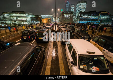 Londres, Royaume-Uni. 28 Nov, 2018. Des taxis noirs bloquer le pont de Londres pour une troisième nuit, et malgré les mauvais temps, dans le cadre de leur Taxi protester contre la décision de TfL de conduire en bloc où les bus sont autorisés - comme dans la rue Tooley et Bnak Junction. Crédit : Guy Bell/Alamy Live News Banque D'Images