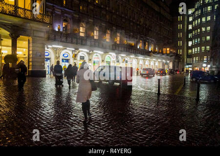 Londres, Royaume-Uni. 28 Nov 2018. Météo France : remblai et le volet en milieu humide, Hiver. Une vue d'hiver de l'Embankment Station, Boris vélos garés dans les casiers, les lumières du théâtre Playhouse, Metropolitan Police VIP escorte, la Tamise avec pluie à nightfal. Les réflexions dans les chaussées rainsoaked par la Savoie et la gare de Charing Cross. Crédit : Peter Hogan/Alamy Live News Banque D'Images