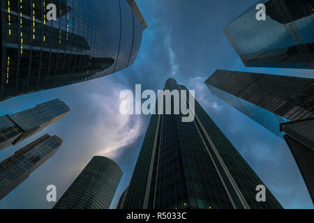 Vue de bas en haut des gratte-ciel et nuages volants Banque D'Images