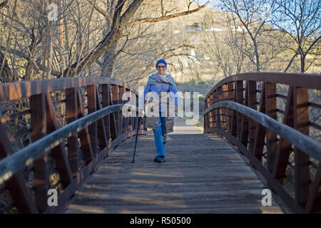 Senior citizen femme marche sur un pont piétonnier de Alpine, Texas. Banque D'Images
