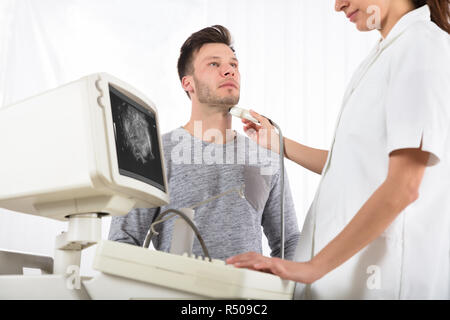 Homme patient en cours d'échographie de la glande thyroïde Banque D'Images