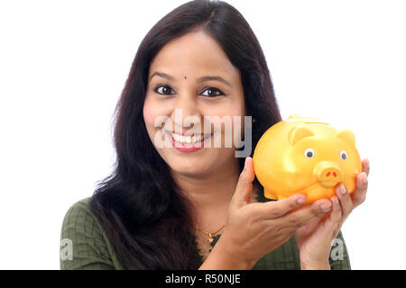 Jeune femme indienne d'économiser de l'argent dans la tirelire Banque D'Images