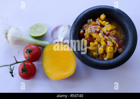 Salsa de mangue dans un bol en pierre avec des ingrédients à l'arrière-plan Banque D'Images