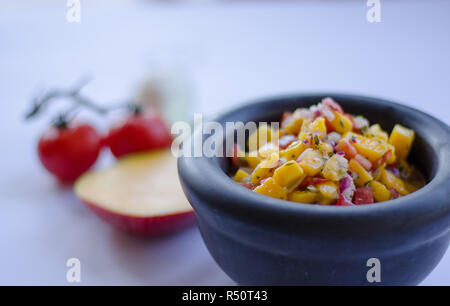 Salsa de mangue dans un bol en pierre avec des ingrédients à l'arrière-plan Banque D'Images