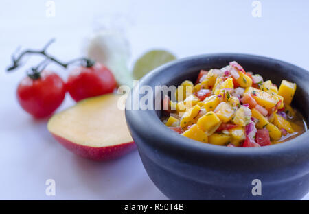 Salsa de mangue dans un bol en pierre avec des ingrédients à l'arrière-plan Banque D'Images