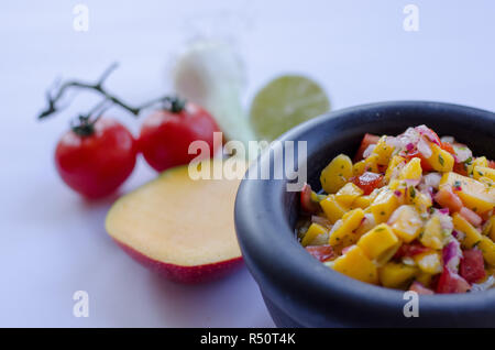 Salsa de mangue dans un bol en pierre avec des ingrédients à l'arrière-plan Banque D'Images