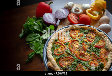 Des légumes frais et des œufs sont des ingrédients sains dans une quiche faite maison Banque D'Images