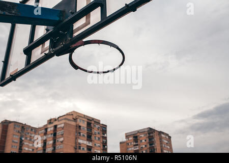 Street ball Basket-ball avec filet déchiré en milieu urbain entourant Banque D'Images