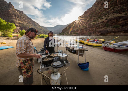 Deux guides de rafting cuire un repas au camp tandis que sur un voyage de rafting de la rivière Verte, la Désolation/Gris section Canyon, Utah, USA Banque D'Images