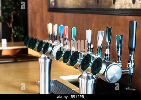 Une ligne de conduite de distributeurs de bière sur un mur en bois à l'intérieur de l'arrière-plan d'un bar à Bergen, Norvège. Banque D'Images