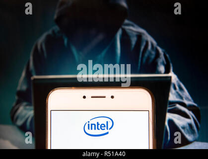 Société multinationale américaine et la technologie des micro-entreprise logo Intel est vu sur un appareil mobile Android avec une figure de hacker dans l'arrière-plan. Banque D'Images