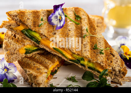 Toasts sain avec de l'avocat, le fromage cheddar et les tomates pour le petit déjeuner ou le déjeuner. Des sandwiches végétariens. Alimentation à base de végétaux. Concept d'aliments entiers. Banque D'Images