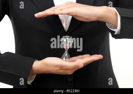 Business Woman holding white contre hourglass Banque D'Images