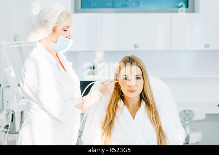 Femme blonde subit une procédure d'oxygène gaz-liquide du visage peeling Banque D'Images