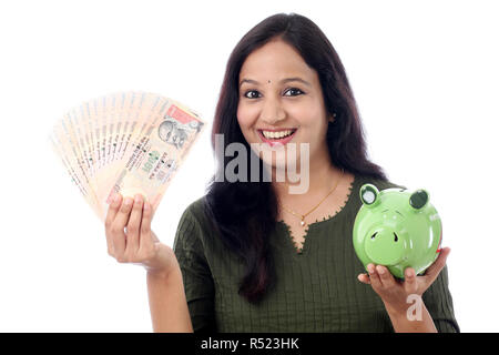 Jeune femme indienne d'économiser de l'argent dans la tirelire Banque D'Images