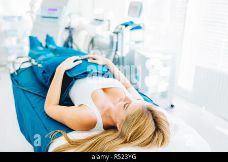 Les jambes de la pressothérapie sur femme patient in hospital bed Banque D'Images