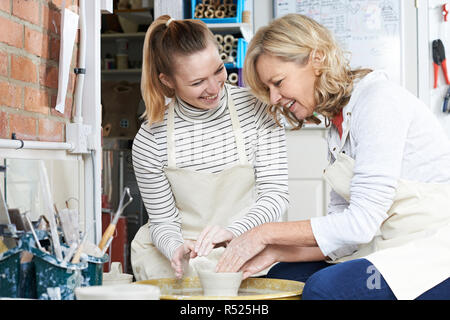 Femme mature avec l'enseignant en classe de poterie Banque D'Images