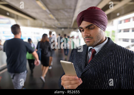 Indian businessman using mobile phone in city Banque D'Images